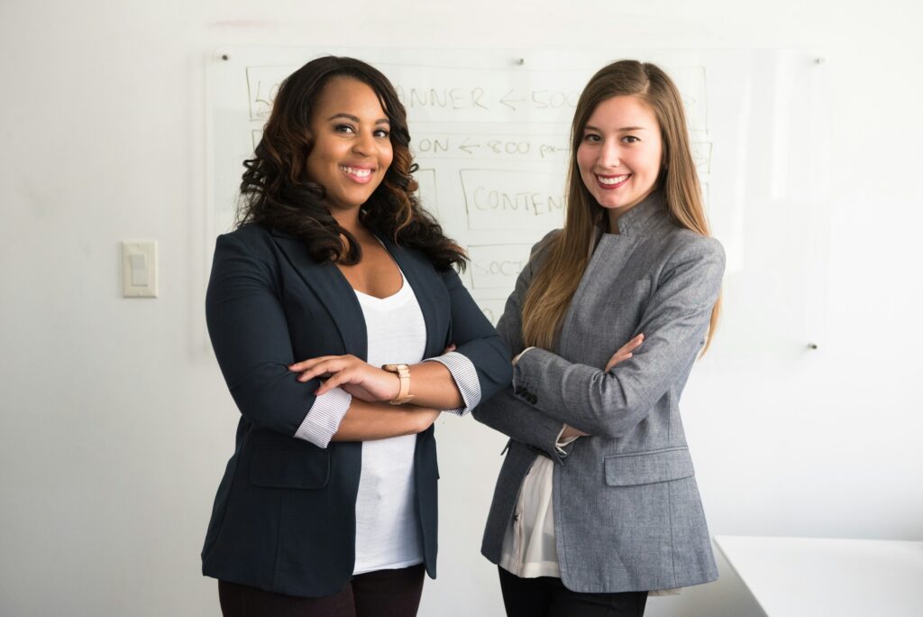 Two women colleagues smiling together in an office
