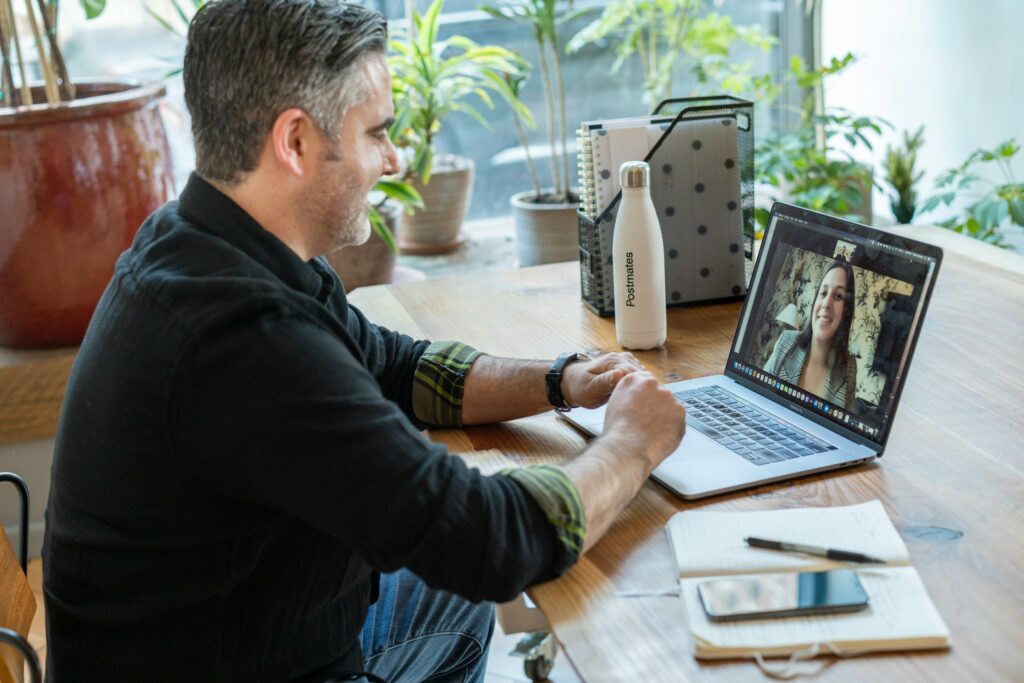 Man using a laptop and phone at his desk