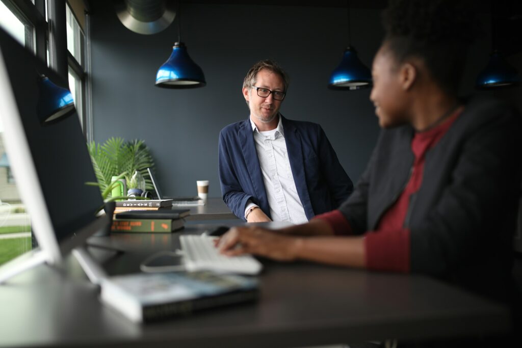 Two colleagues talking at a standing desk in a modern office